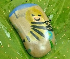 rock with a bee painted on it